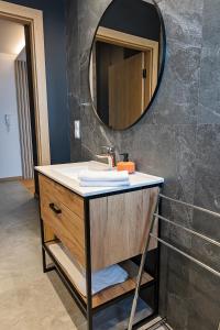 a bathroom with a sink and a mirror at Apartamenty STUDIO M in Busko-Zdrój