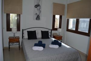ein Schlafzimmer mit einem Bett mit zwei blauen Stühlen darauf in der Unterkunft Eleona's Royal Gardens By Yiota - Luxury 2 Bed Apartment in Exclusive Complex in Peyia