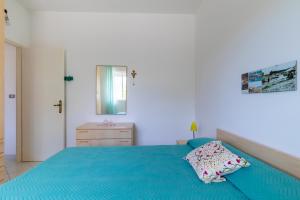 1 dormitorio con 1 cama azul y vestidor en Villetta a due passi dal mare, en Granelli