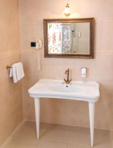 a bathroom with a white sink and a mirror at Hotel Grace in Međugorje