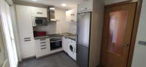 a kitchen with white cabinets and a washer and dryer at Zumaia Basque Alai in Zumaia