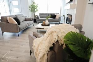 a living room with two couches and a table at Modern Retreat 3 King Beds,Garage,Disney in Edmonton