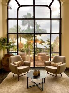 a living room with two chairs and a large window at Hotel Porto Mare - PortoBay in Funchal