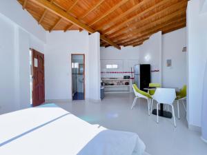 Condominio bahia blanca في كوفيناس: غرفة نوم بسرير وكراسي ومطبخ