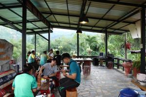 een groep mensen die aan tafel zitten in een restaurant bij ภูผาฮิลล์ รีสอร์ท in Lan Saka