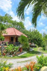 uma casa num jardim com árvores e plantas em ภูผาฮิลล์ รีสอร์ท em Lan Saka