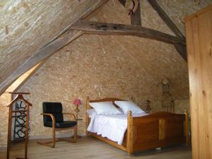 ein Schlafzimmer mit einem Bett und einem Stuhl im Dachgeschoss in der Unterkunft Gîte Onze in Liessies