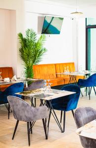 una sala da pranzo con tavoli, sedie e una pianta di Hôtel les Vallons a Abidjan