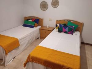 two beds sitting next to each other in a room at Apartamento Puente in Portonovo