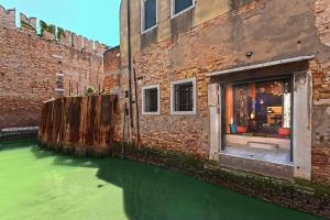 a window in a brick building with green water at Ca' Ranieri Tenti in Venice