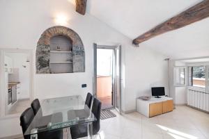 une salle à manger avec une table en verre et une cuisine dans l'établissement Serra Trilocale, à Bonassola