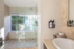 a bathroom with a shower and a sink at Bali and Eva Fresnaye. Luxurious 7 bedroom villa. Pool and grand patio in Cape Town