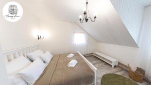 a white bedroom with a bed and a window at Penzión Čarovný dvor 