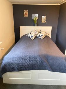 a bedroom with a blue bed with two pillows at Guesthouse Dybbøl, Sønderborg in Sønderborg