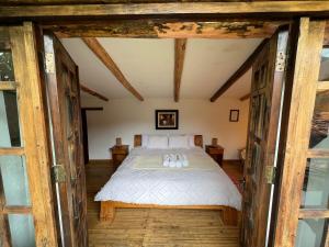 1 dormitorio con 1 cama en una habitación con ventanas en CASONA LARA Lodge & Distillery, en Caraz