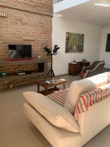 sala de estar con sofá y TV en Hermoso dúplex interno en la mejor zona de Mendoza en Mendoza