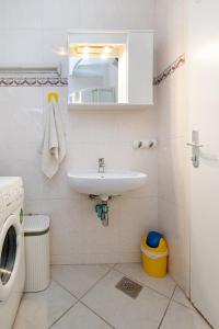 La salle de bains est pourvue d'un lavabo et d'un lave-linge. dans l'établissement Apartment Bazen, à Zadar