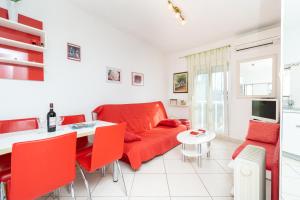 - un salon avec un canapé rouge et une table dans l'établissement Apartment Bazen, à Zadar