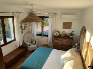 a bedroom with a bed and a chair and a window at Moraira vue mer et montagne in Teulada