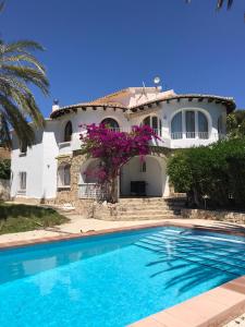 a house with a swimming pool in front of a house at Moraira vue mer et montagne in Teulada