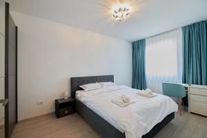 a bedroom with a bed with a desk and a window at Alessandro Home 7 Luxury Centru Palas Mall Iași Q Residence in Iaşi