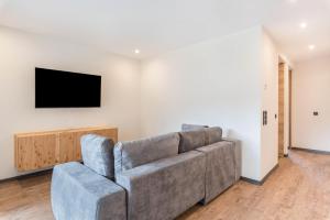 a living room with a couch and a tv on a wall at Villa Lara Zirbe in Castelrotto