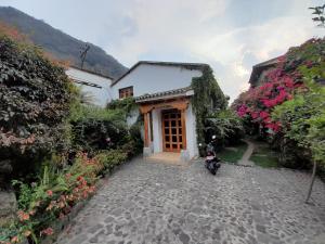 una motocicleta estacionada frente a un edificio con flores en Hostal Casa Búho, en Antigua Guatemala