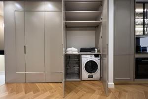 eine Küche mit Waschmaschine und Trockner im Schrank in der Unterkunft Ambassador Tallinn in Tallinn