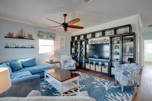 sala de estar con sofá azul y TV en Fort Myers Home Near Sanibel Island Causeway, en Fort Myers