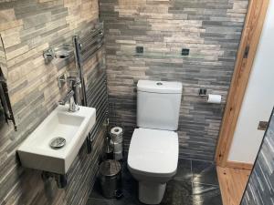 uma casa de banho com um WC branco e um lavatório. em Kevalsya em Truro