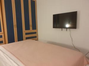 a bedroom with a bed and a flat screen tv on the wall at BELLE CHAMBRE CONFORTABLE in Netanya