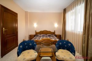 Schlafzimmer mit einem Bett, einem Tisch und Stühlen in der Unterkunft Hotel Chuchulev in Sozopol