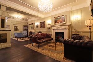 a living room with leather furniture and a fireplace at The Georgian Swansea in Swansea