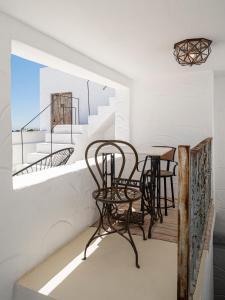 a room with two chairs and a table on a balcony at La Fonda Antigua ADULTS ONLY in Vejer de la Frontera