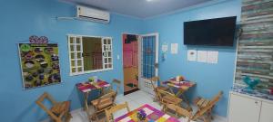 ein Esszimmer mit blauen Wänden, Tischen und Stühlen in der Unterkunft Hotel Colors Manaus in Manaus