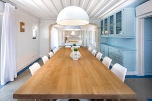 a dining room with a long table and white chairs at Shantivillas Malhão in Azinhal +145 photos