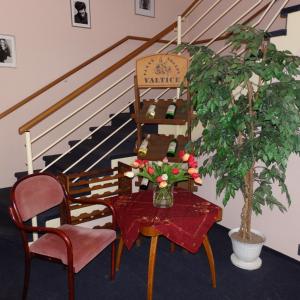 a table and chair with a plant and a staircase at Apartmany Cesky Dvur in Mariánské Lázně