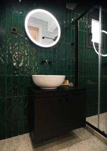 un bagno piastrellato verde con lavandino e specchio di Plane Tree Luxury Suites a Ioannina
