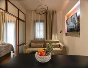 a living room with a table with a bowl of fruit at Plane Tree Luxury Suites in Ioannina