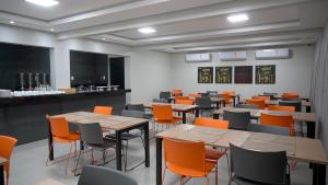 a classroom with tables and chairs and a chalkboard at Hotel Tupinambá in Santa Inês