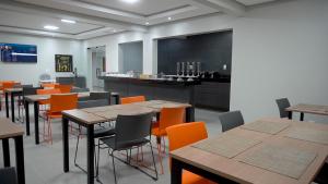 uma sala de jantar com mesas e cadeiras laranja em Hotel Tupinambá em Santa Inês