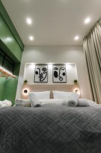 a bedroom with a large bed with posters on the wall at Plane Tree Luxury Suites in Ioannina