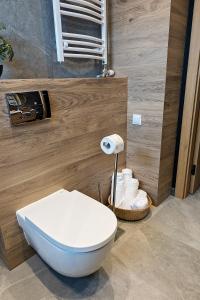 uma casa de banho com um WC branco e uma cesta de papel higiénico em Apartamenty STUDIO M em Busko-Zdrój