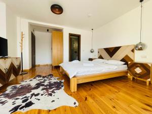 1 dormitorio con cama y alfombra en el suelo de madera en PANORAMIC Sus In Deal, en Vişeu de Jos