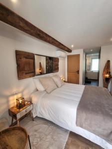 una camera da letto con un grande letto bianco e un tavolo di La voute du pilat a Saint-Chamond