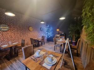a restaurant with tables and chairs and a brick wall at La voute du pilat in Saint-Chamond