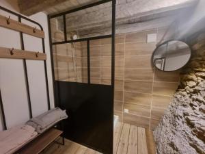 a shower with a glass door in a room at La voute du pilat in Saint-Chamond