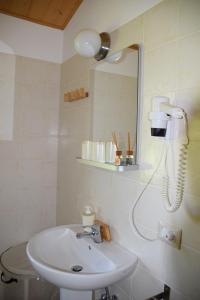 uma casa de banho com um lavatório, um chuveiro e um espelho. em Valle del Lupo em San Ginesio