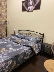 a bedroom with a bed with a blue comforter at Uneed Rooms Somnium in Kyiv +24 photos