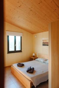 Un dormitorio con una cama con dos zapatos. en Valle del Lupo, en San Ginesio